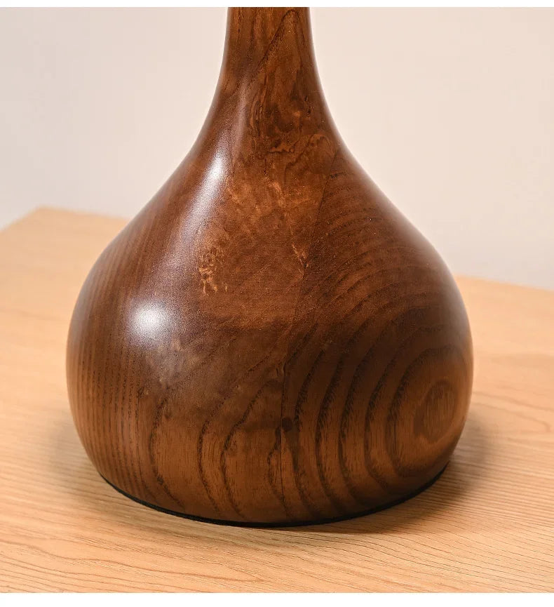 Wooden vase on a wooden surface with a plain background