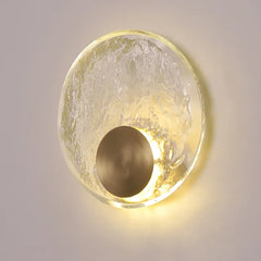 Round wall light fixture with textured glass cover on a neutral background