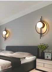 Modern bedroom with wall lights, bed, and nightstand.