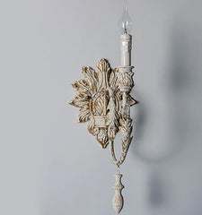 Decorative wall sconce with intricate design on a plain background