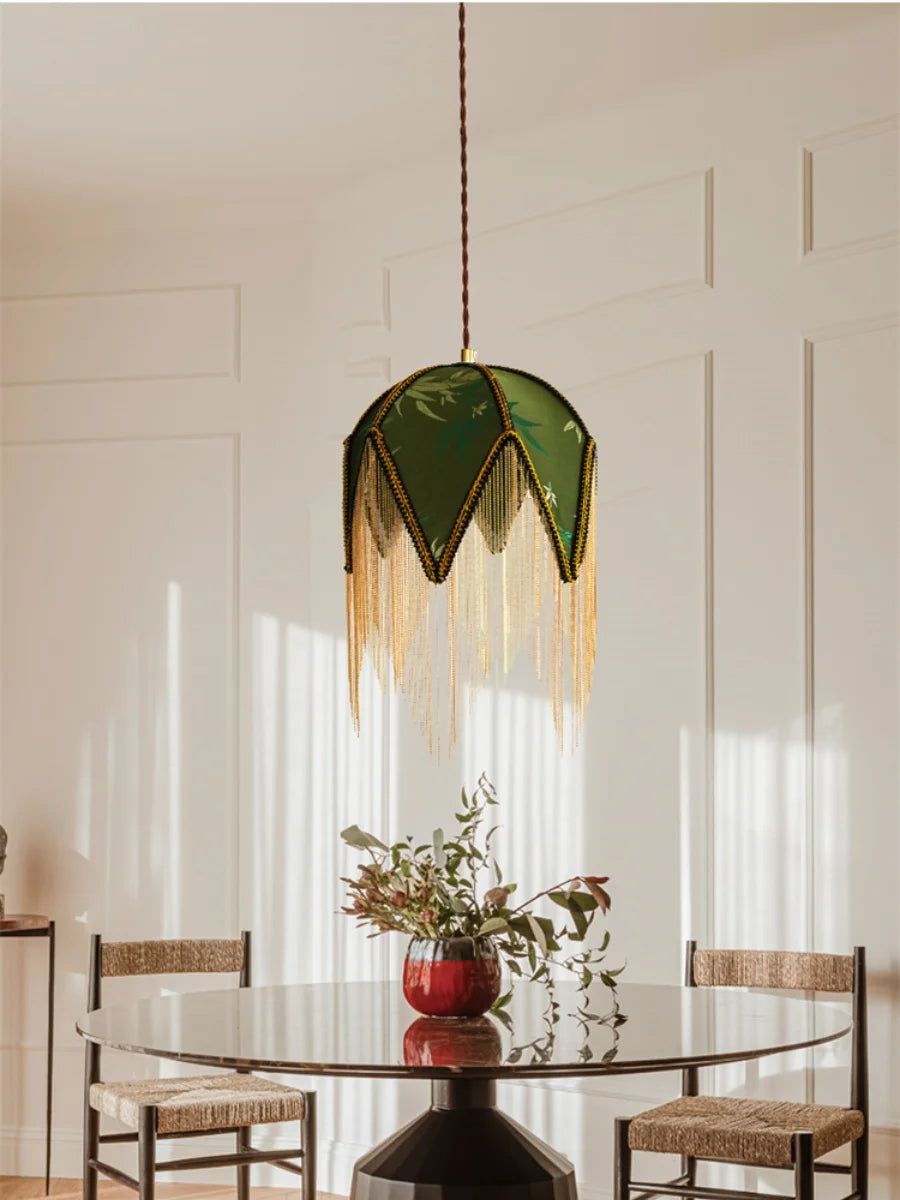 Modern dining room with a green pendant light, round table, and chairs.