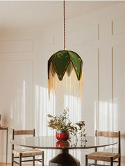 Modern dining room with a green pendant light, round table, and chairs.