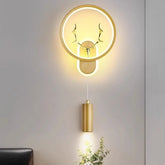 Gold wall sconce with circular LED halo and integrated antler design, with a hanging downlight cylinder.