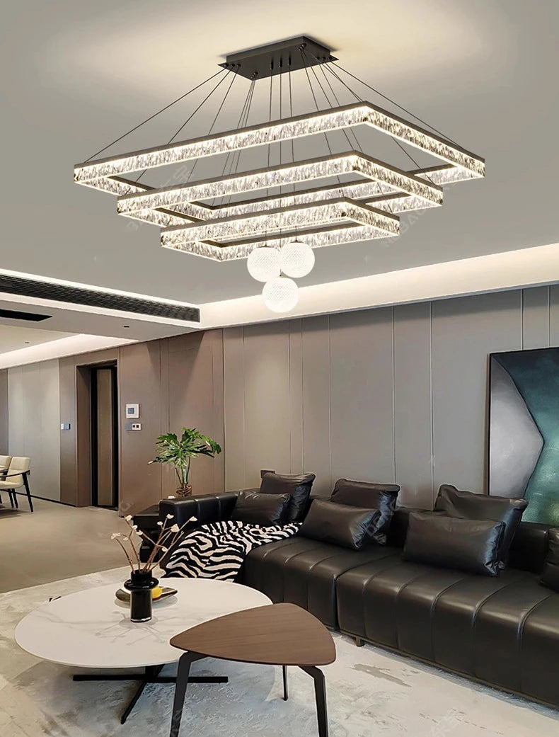 Modern living room with a chandelier, sofa, and coffee table.
