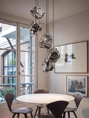 Modern dining room with a round table and chairs, featuring a unique pendant light fixture.
