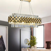 Gold and crystal tiered chandelier with geometric pattern, shown in a modern dining room setting.