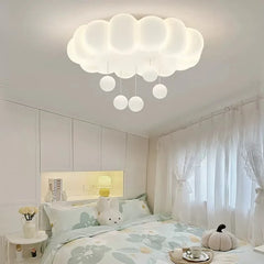 White cloud-shaped ceiling fixture with small white globe pendants, installed in a bedroom.
