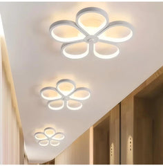 Three white flower-shaped semi-flush mount ceiling lights arranged in a line down a hallway