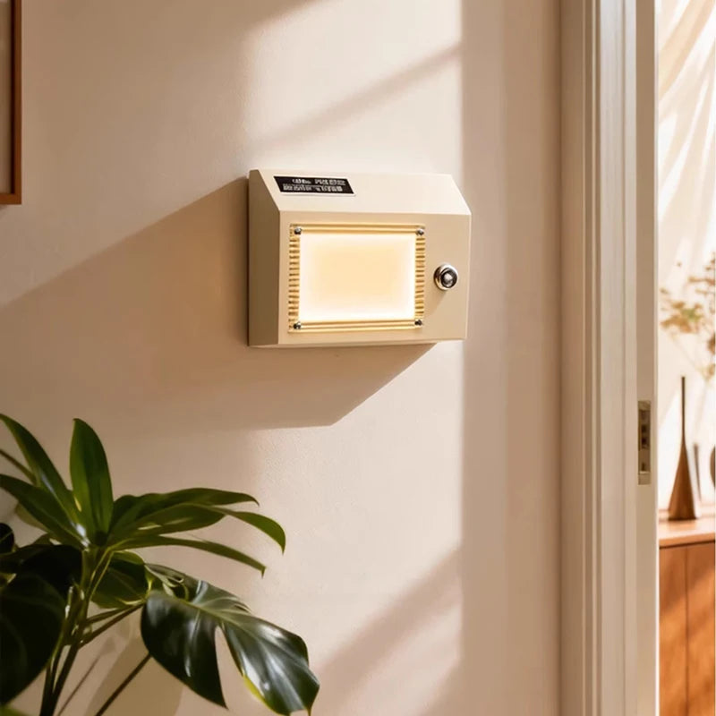 Cream colored retro radio shaped wall sconce mounted on a white wall, casting a warm glow.
