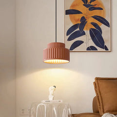 Pink tiered resin pendant light casting a warm glow in a living room