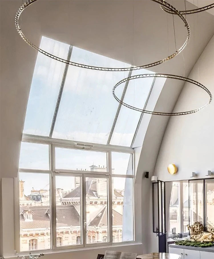 Modern interior with large windows, chandelier, and desk.