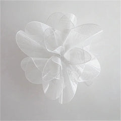 White floral decorative item on a light gray background