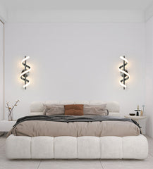 Modern bedroom with a bed, wall lights, and minimal decor.