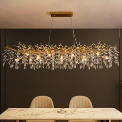 Luxury chandelier hanging above a dining table with marble surface and chairs.