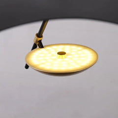 Close-up of a round, gold-colored LED light on a gray background