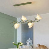 Green floral chandelier with acrylic flower shades and a green stem, hanging from a ceiling.