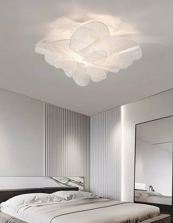 Modern ceiling light fixture in a bedroom setting with a bed and mirror.
