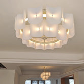 Gold tiered acrylic wave chandelier with multiple layered shades illuminated