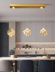 Modern kitchen with gold pendant lights and minimalistic decor.