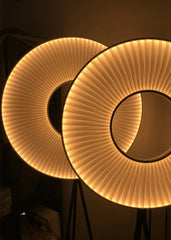 Two round, illuminated lamps with a warm glow on a dark background