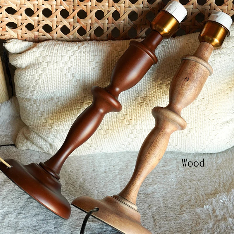 Wooden candlesticks with gold and white candle holders on a textured surface.