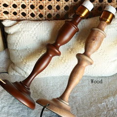 Wooden candlesticks with gold and white candle holders on a textured surface.