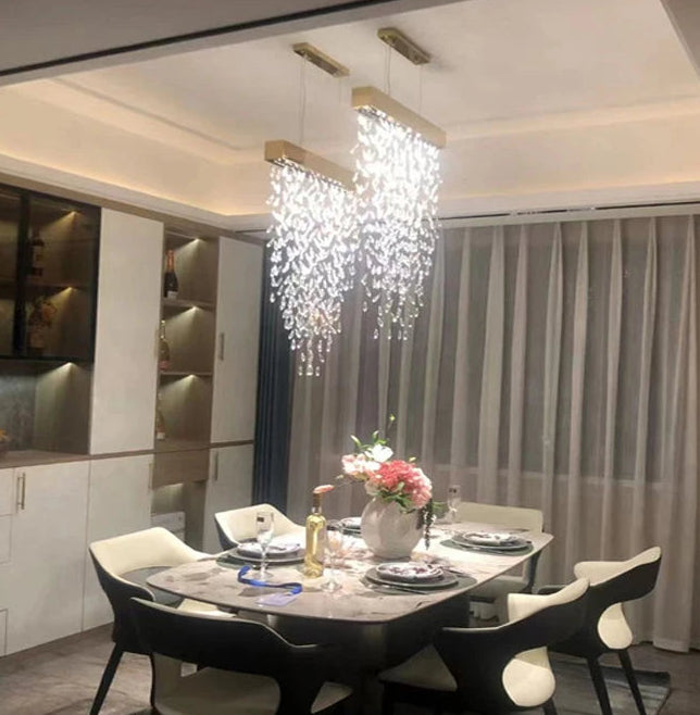 Modern dining room with a chandelier, table setting, and decorative elements.
