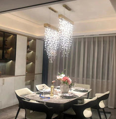 Modern dining room with a chandelier, table setting, and decorative elements.