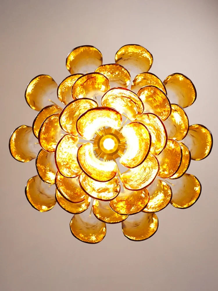 Decorative ceiling light fixture with gold circular design on a plain background