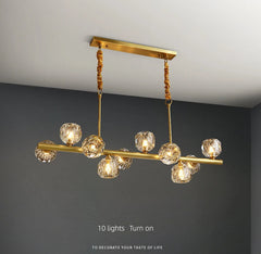 Gold chandelier with crystal-like glass shades on a gray background