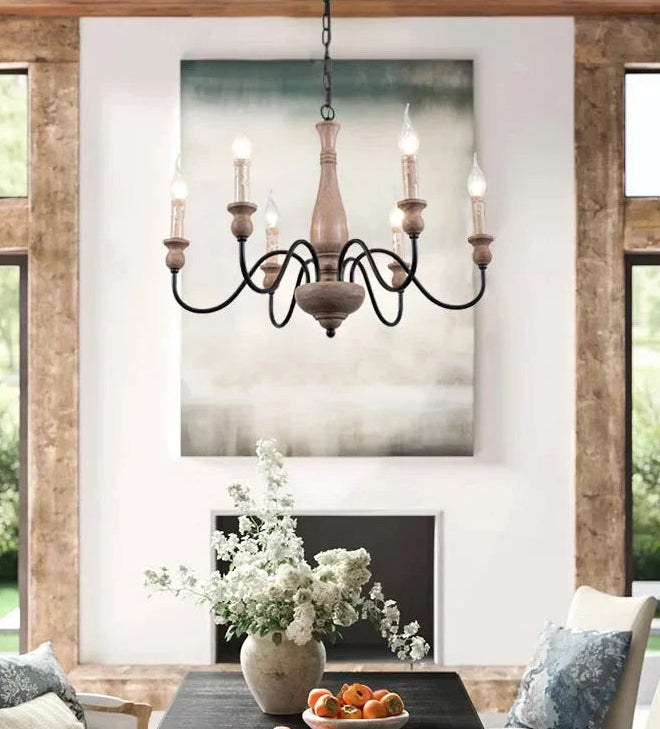 Living room with wooden chandelier, floral arrangement, and fruit bowl.