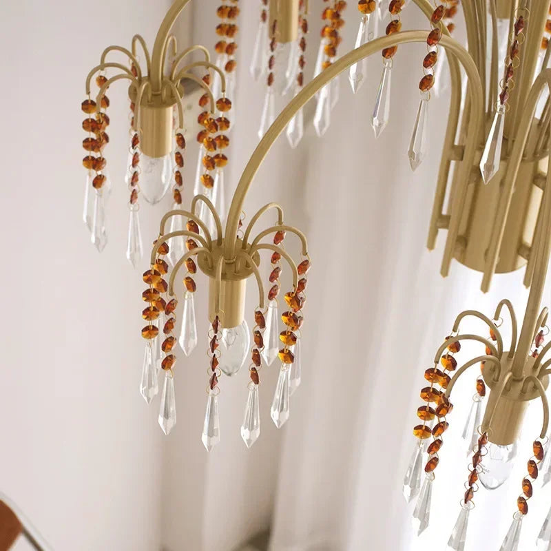 Detail shot of the intricate design of a gold chandelier, showing the arrangement of crystal pendants and beaded strands.