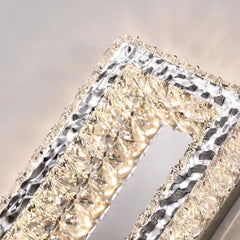 Decorative wall light fixture with crystal-like design on a neutral background