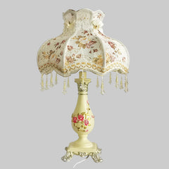 Decorative table lamp with floral design on a plain background