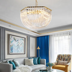 Gold crystal waterfall chandelier with cascading clear glass tubes and a polished gold frame, illuminating a modern living room.