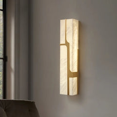 Modern wall sconce with marble-like finish on a gray wall