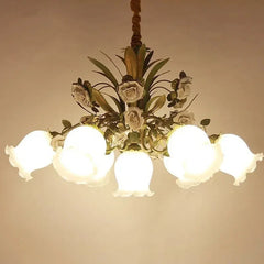 View of a gold floral chandelier with multiple illuminated frosted glass shades, showcasing its decorative elements.
