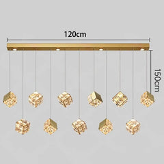 Gold pendant light fixture with crystal-like shades on a gray background