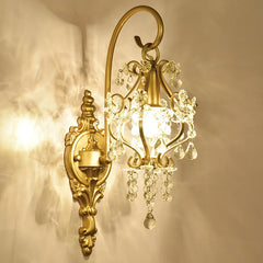 Decorative gold wall sconce with crystal accents on a beige wall.