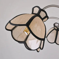 Detailed view of a light beige, petal-shaped shade on a polished chrome chandelier, showing the internal light bulb.