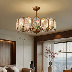 Copper frame chandelier with oval acrylic panels featuring lotus floral designs, illuminating a living room.