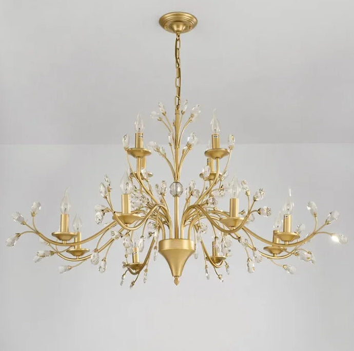 Gold chandelier with crystal accents on a gray background