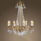 A gold-toned chandelier with multiple candle-style lights and cascading clear teardrop crystals.