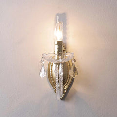 Decorative wall sconce with crystal details on a plain wall.