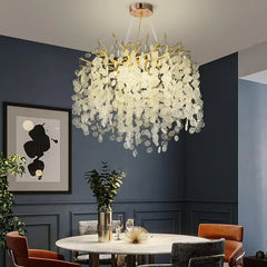 Gold cascading crystal pendant light illuminating a dining room with a round table and dark blue walls.