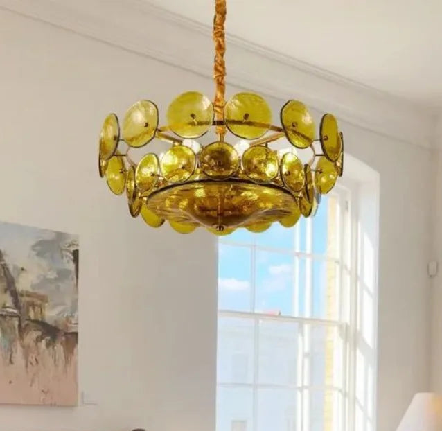 Gold chandelier hanging in a room with a bed and window