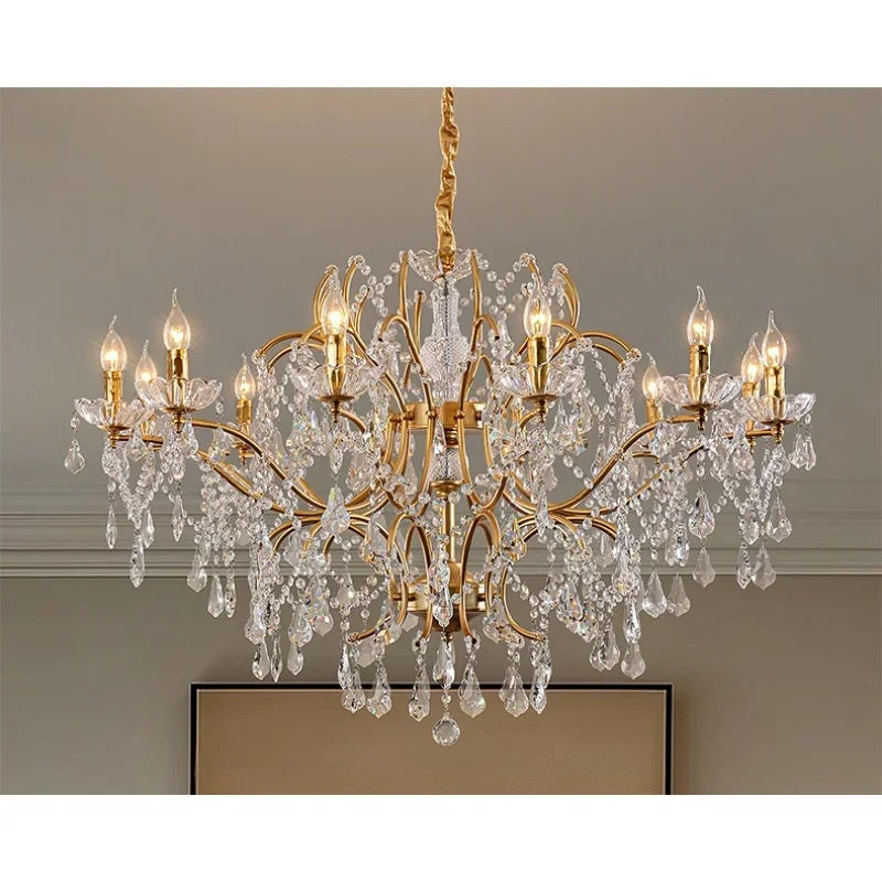 View of a gold chandelier with multiple tiers of crystal beading and cascading pendants, emitting a warm glow.