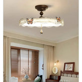 Bronze butterfly drum semi-flush ceiling light with crystal accent, displayed in a bedroom.