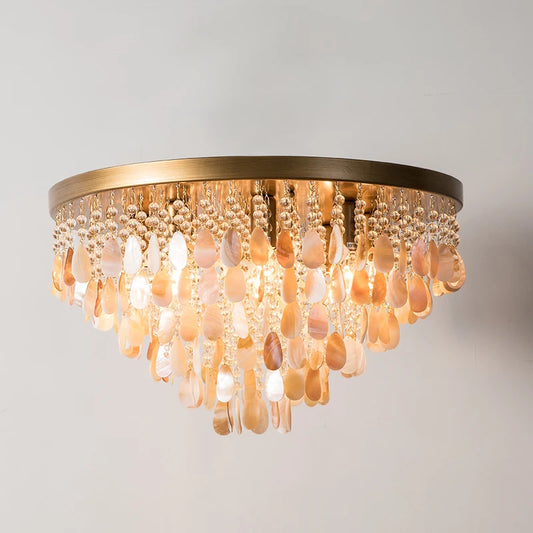 Close-up view of the gold shell and crystal cascading pendant light fixture against a white background.