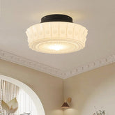 White frosted glass drum semi-flush ceiling light mounted on a white ceiling.